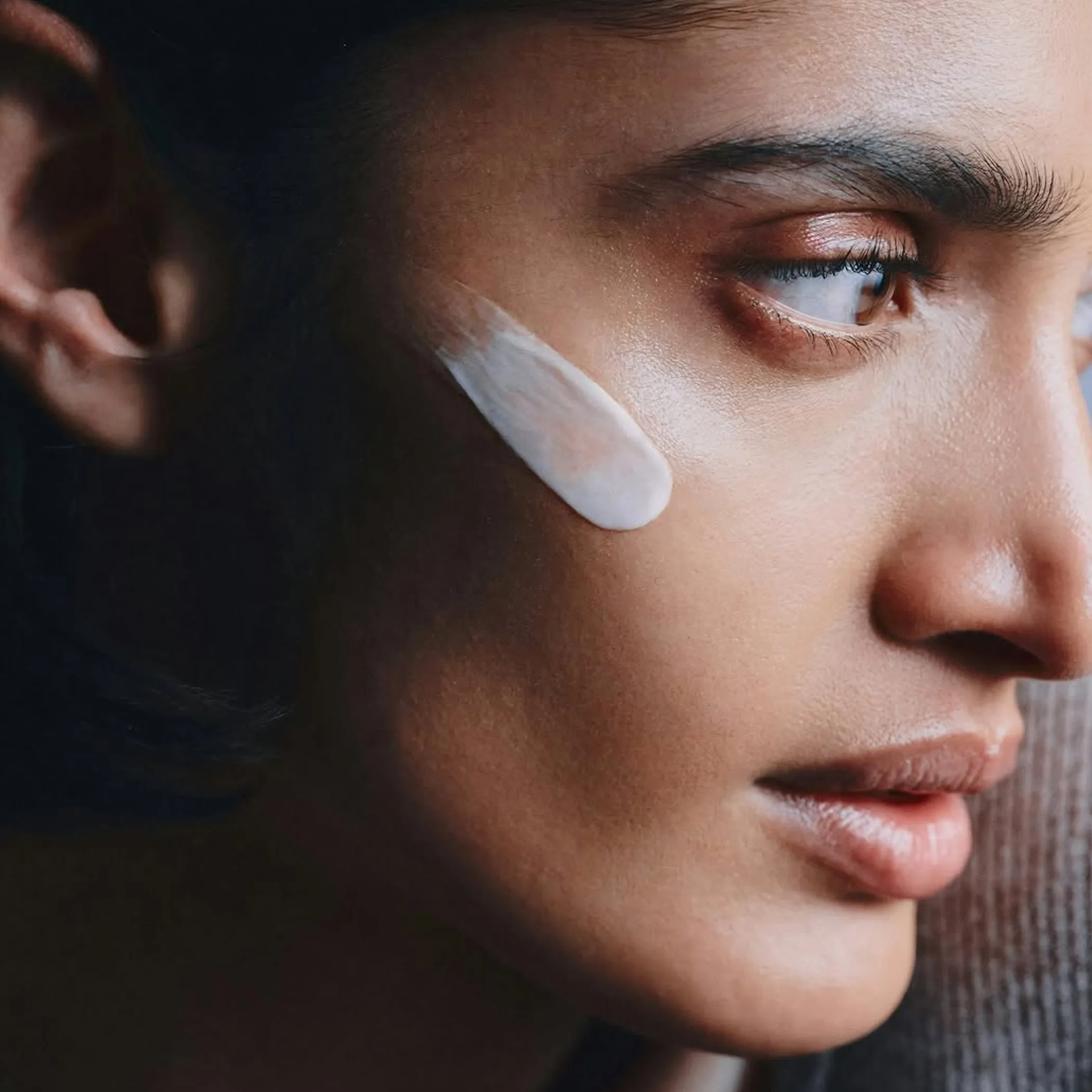 person applying cream to face