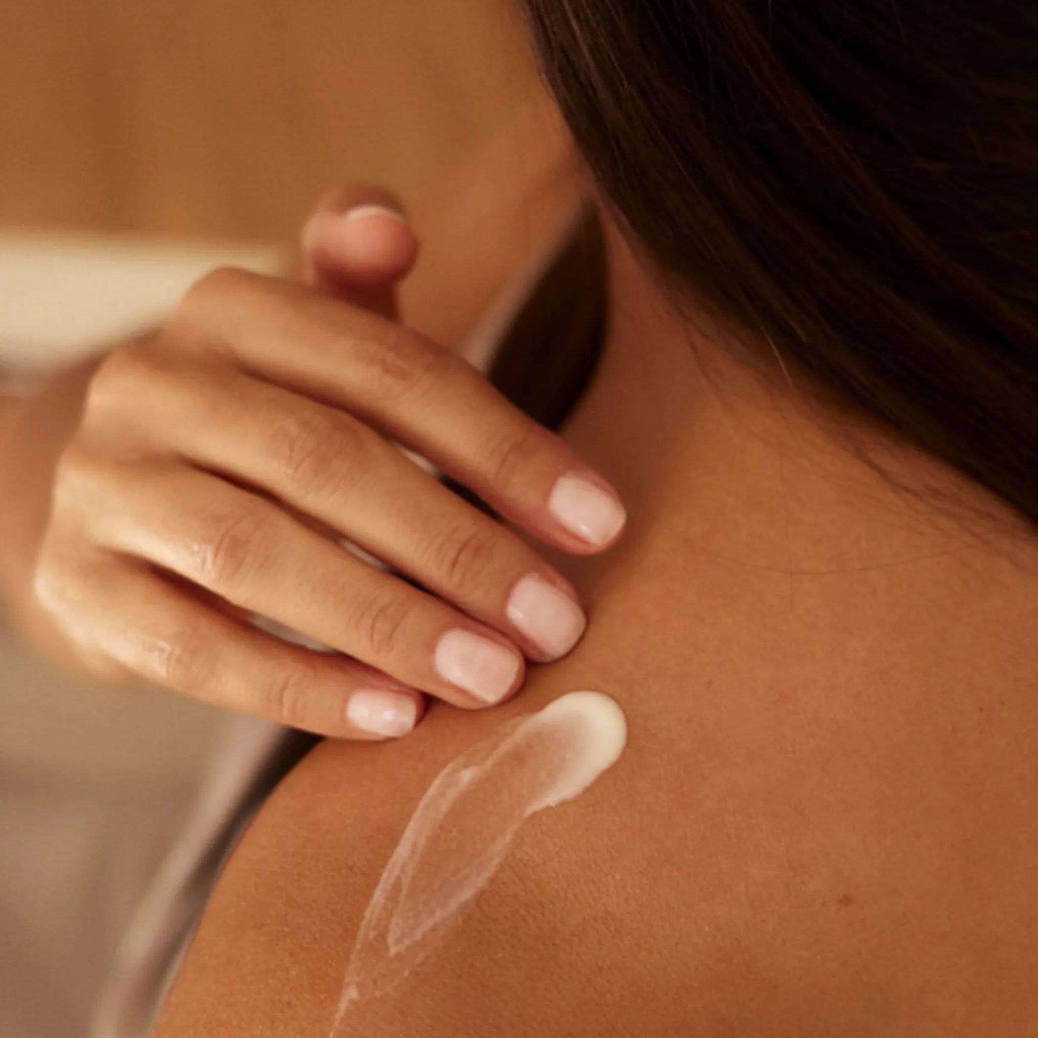 woman applying cream on face